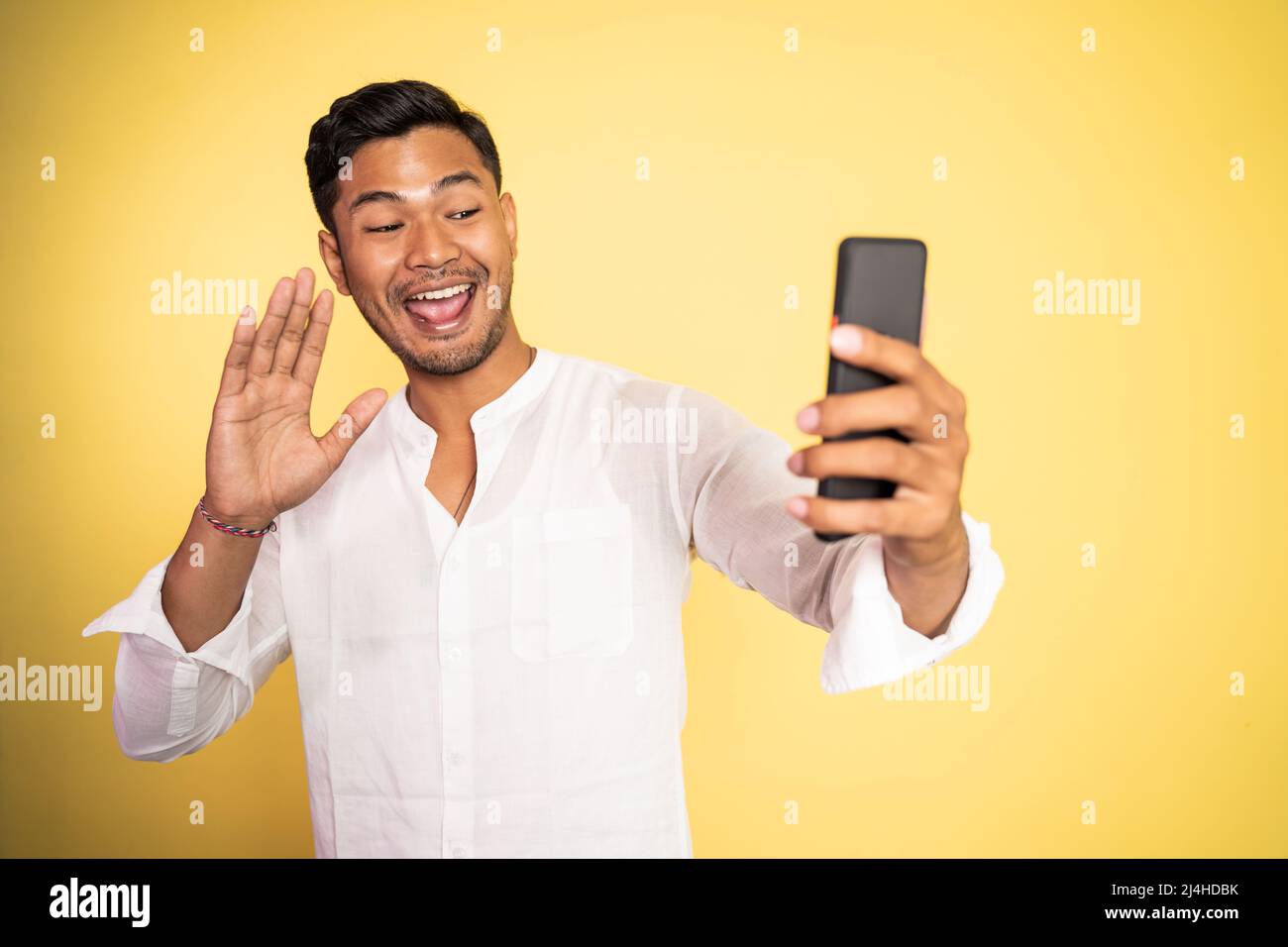 messaggio di saluto di un uomo asiatico durante una videochiamata telefonica utilizzando lo smartphone Foto Stock