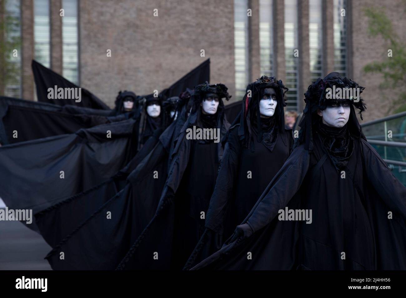 Londra, Regno Unito. 15th Apr 2022. Gli attivisti si esibiscono mentre camminano lungo il Millennium Bridge. Gli attivisti del gruppo di proteste sul clima Extinction Rebellion vestito da brigate nere e si esibiscono in mimi, movimenti al rallentatore e tableaux in pubblico per protestare contro gli investimenti di combustibili fossili da parte del governo britannico e l'impatto dei combustibili fossili per l'ambiente. Credit: SOPA Images Limited/Alamy Live News Foto Stock