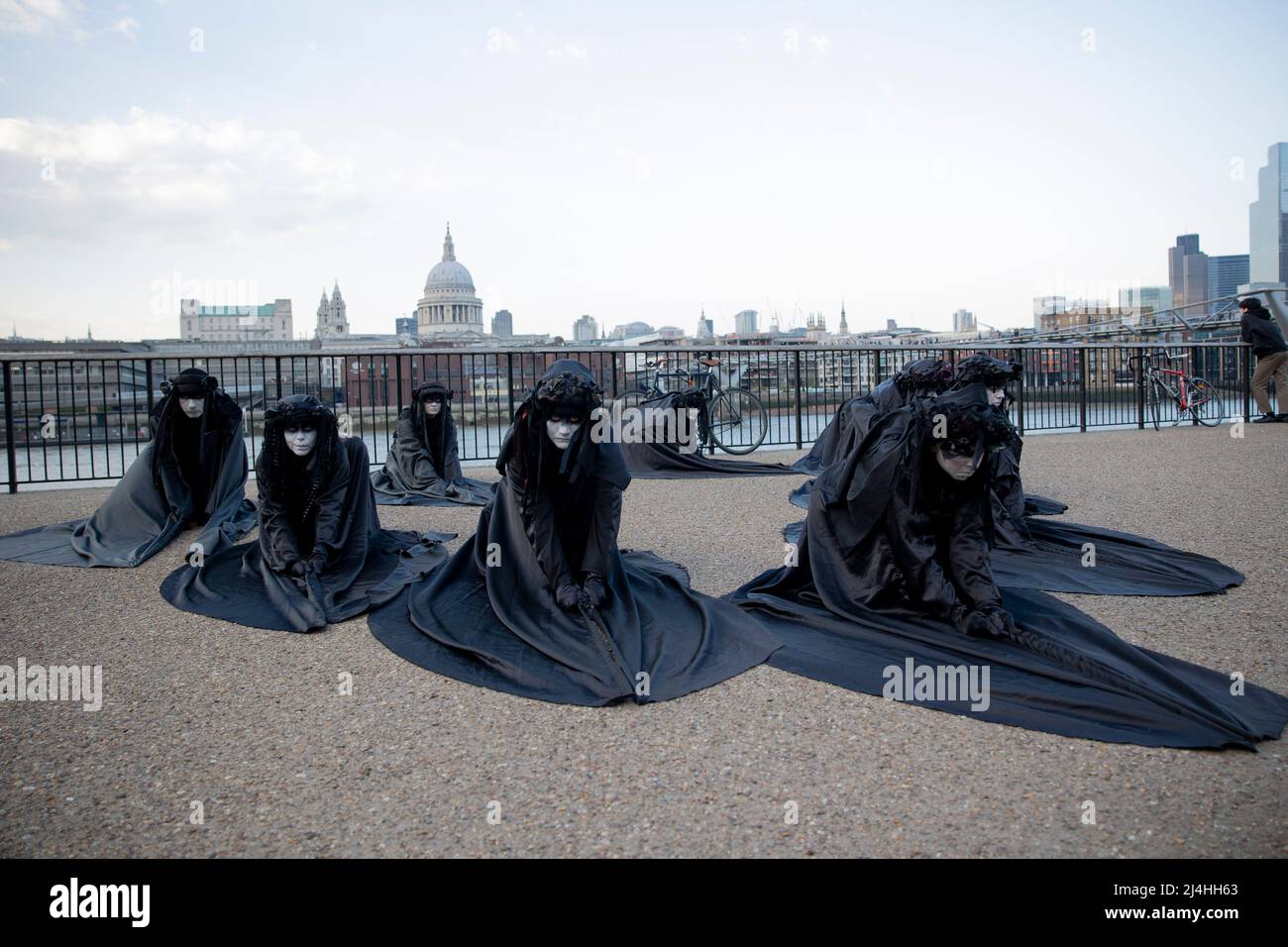 Londra, Regno Unito. 15th Apr 2022. Gli attivisti si esibiscono presso il Bankside. Gli attivisti del gruppo di proteste sul clima Extinction Rebellion vestito da brigate nere e si esibiscono in mimi, movimenti al rallentatore e tableaux in pubblico per protestare contro gli investimenti di combustibili fossili da parte del governo britannico e l'impatto dei combustibili fossili per l'ambiente. Credit: SOPA Images Limited/Alamy Live News Foto Stock