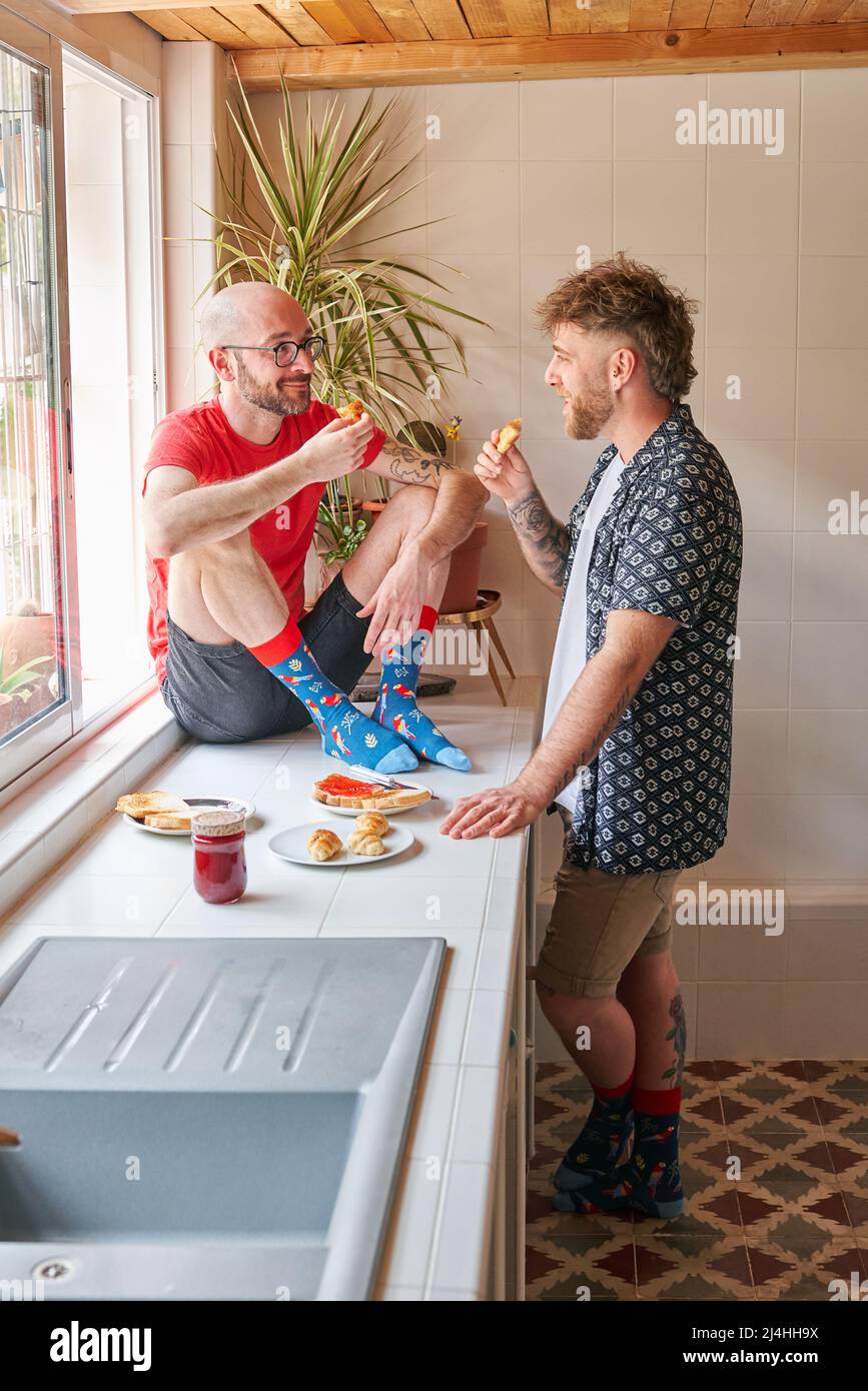 Coppia gay che consumata la colazione sul banco della cucina Foto Stock