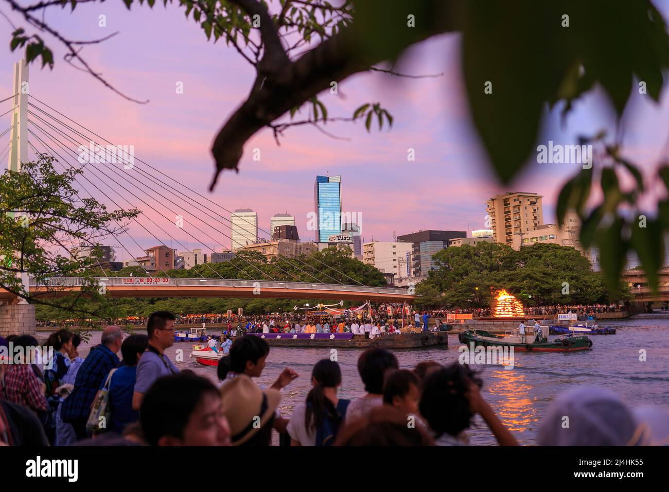 Osaka, Giappone - 25 luglio 2015: Folla di persone si allineano lungo il fiume per guardare le barche cerimoniali al festival estivo Foto Stock