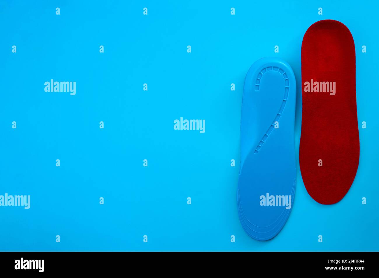 Supporto per il piede e piedi sani con solette ortopediche isolate su sfondo blu con spazio di copia Foto Stock