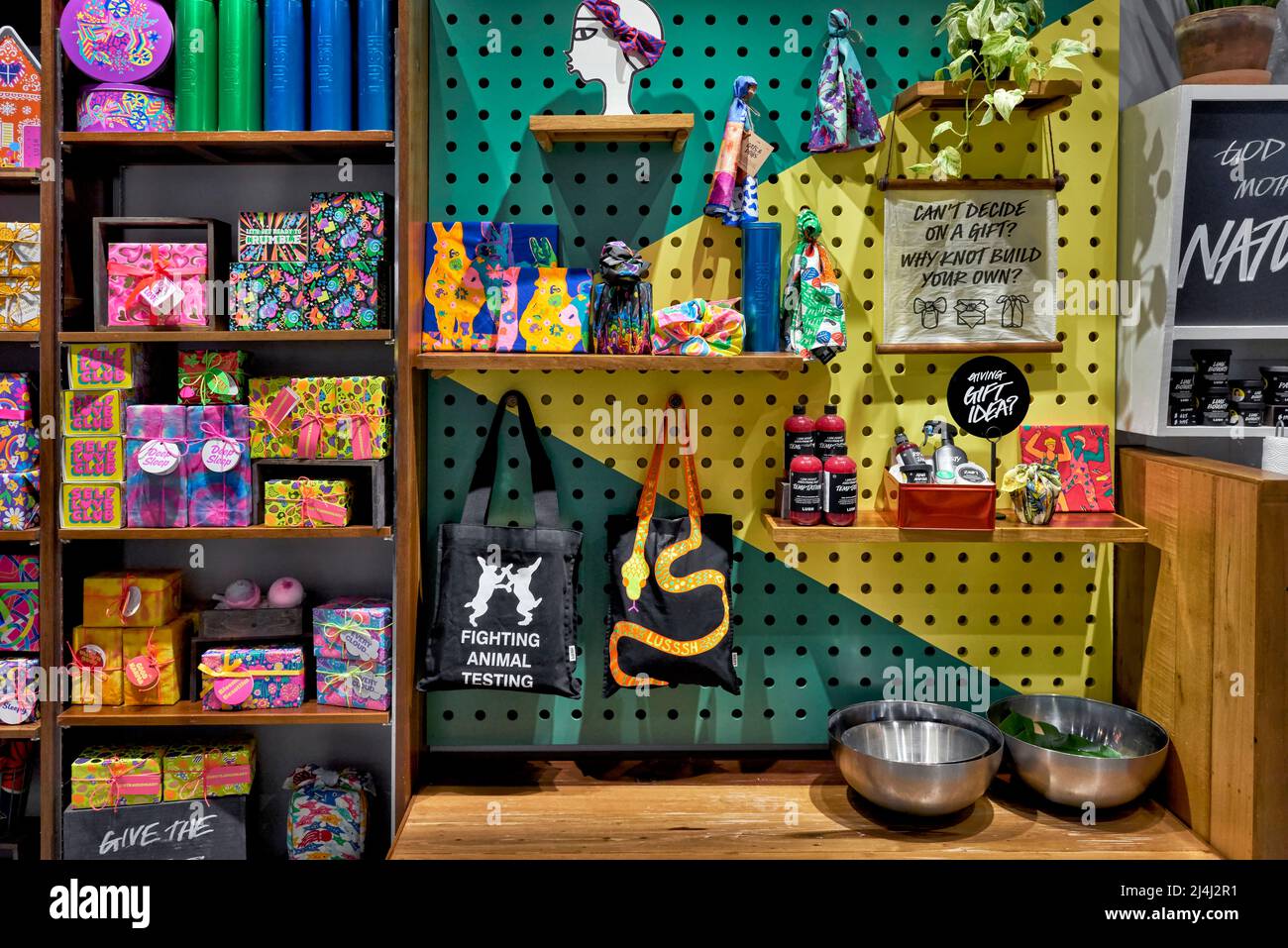 Regali avvolti su un'unità espositore da scaffale che offre un assortimento colorato di regali confezionati Foto Stock