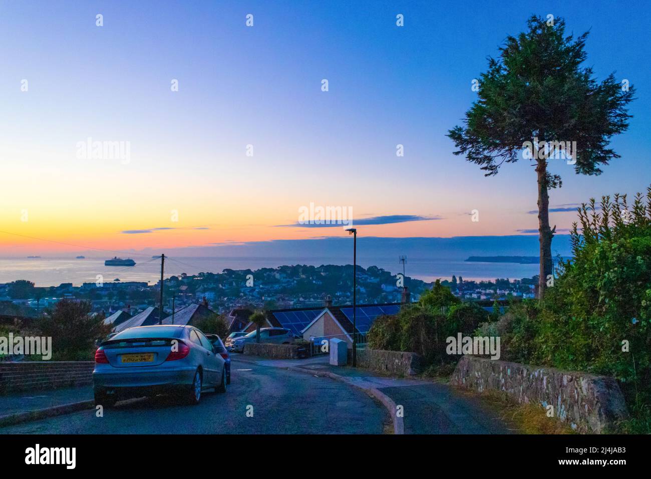 Alba sulle strade collinari di Paignton e la baia in bella mattinata estiva.Paignton è una città di mare sulla costa di Tor Bay in Devon, Inghilterra. Foto Stock