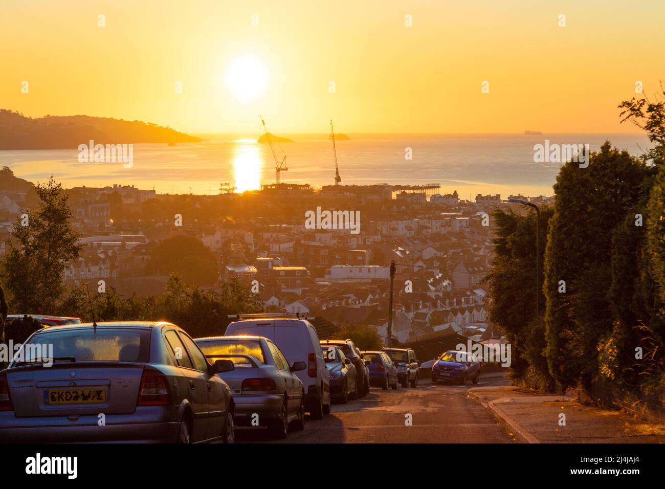 Alba sulle strade collinari di Paignton e la baia in bella mattinata estiva.Paignton è una città di mare sulla costa di Tor Bay in Devon, Inghilterra. Foto Stock