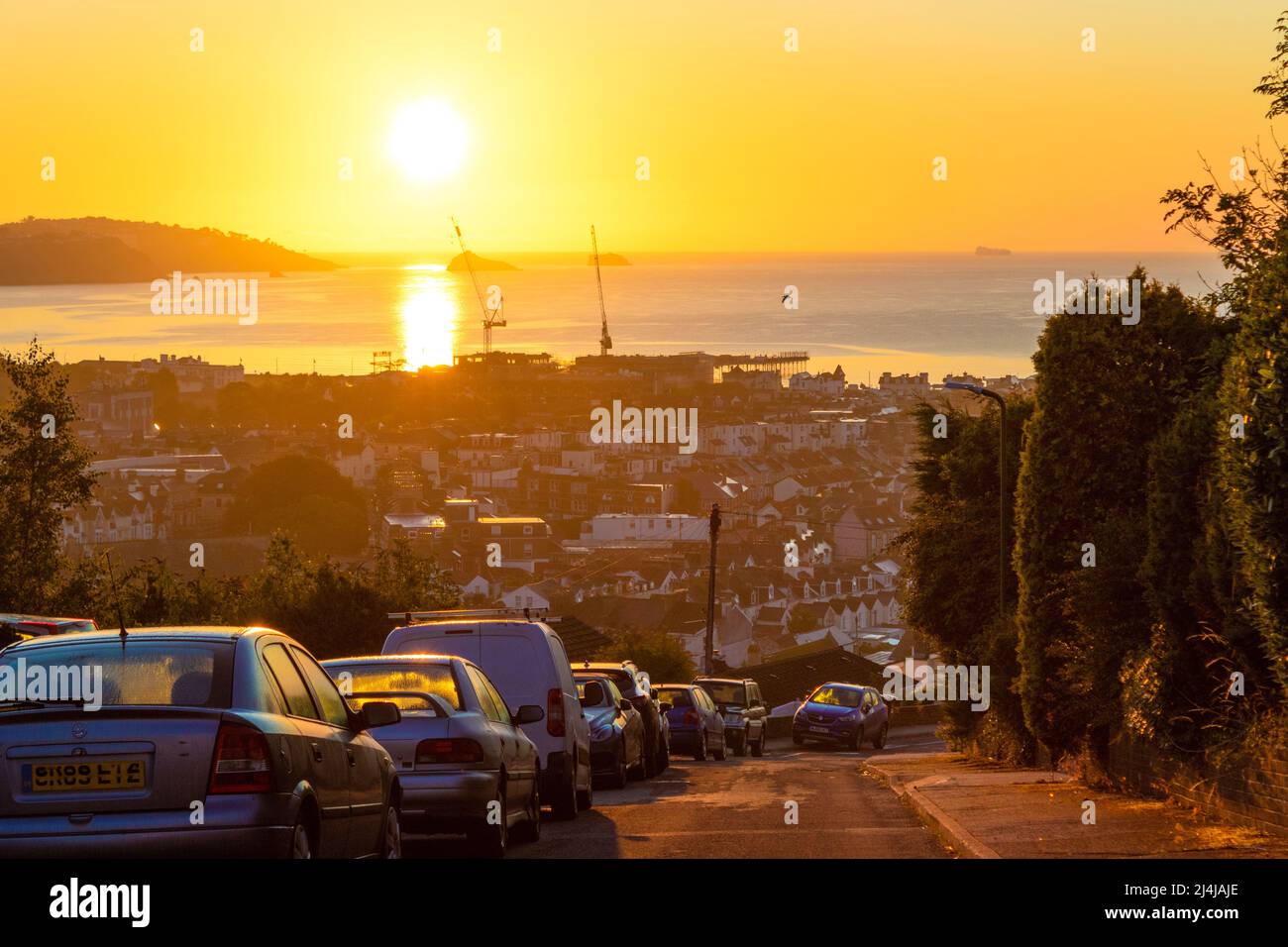 Alba sulle strade collinari di Paignton e la baia in bella mattinata estiva.Paignton è una città di mare sulla costa di Tor Bay in Devon, Inghilterra. Foto Stock