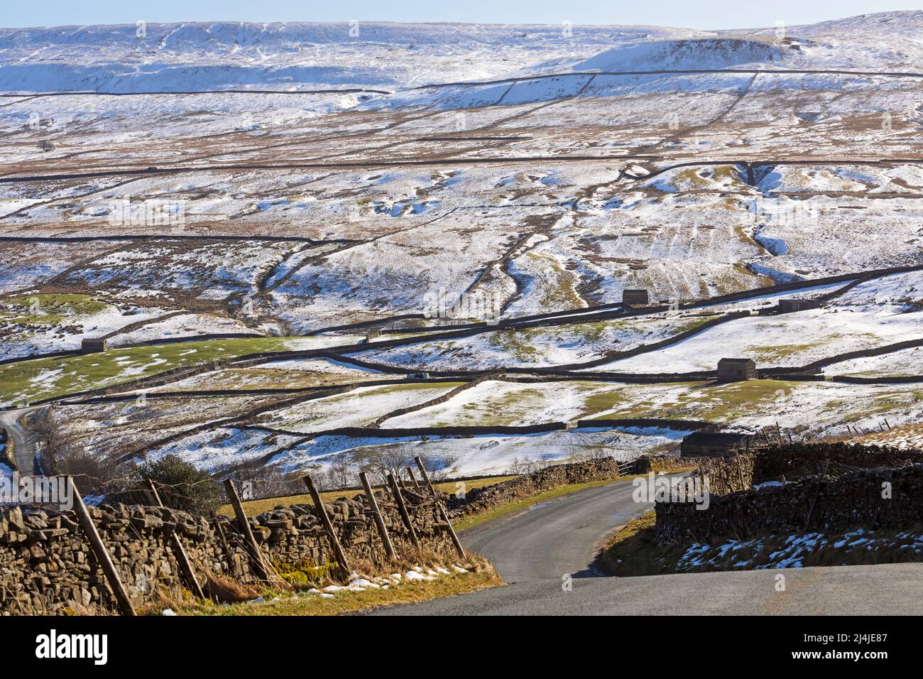 Curve ripide su B6270 in una giornata invernale a Swaledale, Yorkshire Dales National Park. La neve copre le campane sopra la valle vicino a Keld. Foto Stock