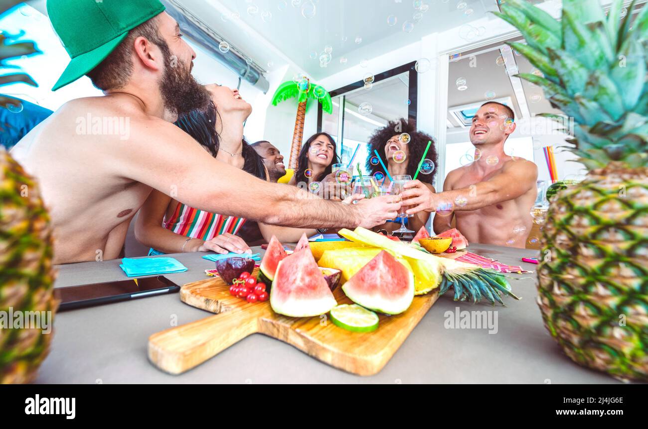 Amici felici che tostano cocktail tropicali a festa in barca - giovani millenni che si divertono in vacanza di lusso - concetto di stile di vita di viaggio con millen Foto Stock