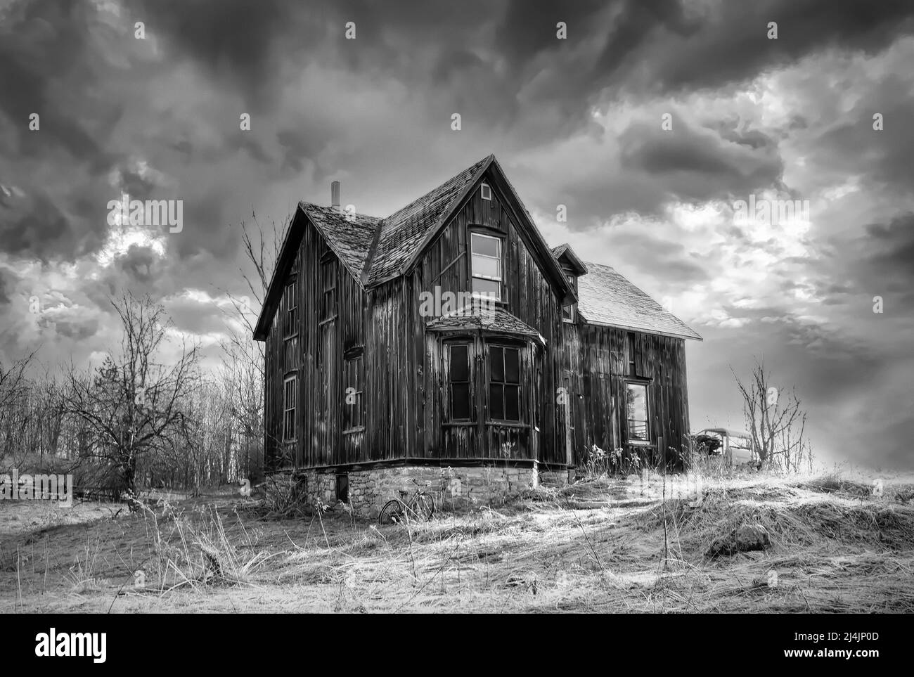 Un vecchio nero e bianco abbandonato spooky cercando fattoria in inverno su un cortile fattoria nel Canada rurale Foto Stock