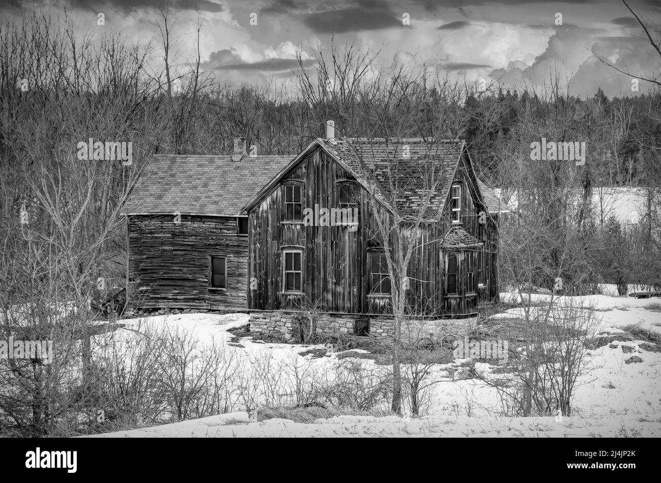Un vecchio nero e bianco abbandonato spooky cercando fattoria in inverno su un cortile fattoria nel Canada rurale Foto Stock