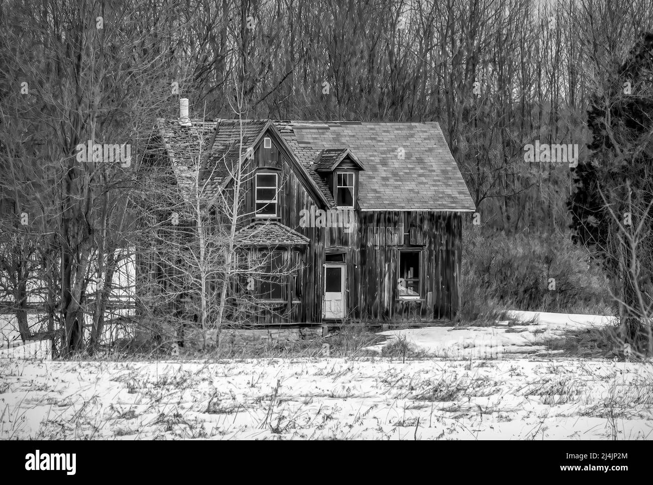 Un vecchio nero e bianco abbandonato spooky cercando fattoria in inverno su un cortile fattoria nel Canada rurale Foto Stock