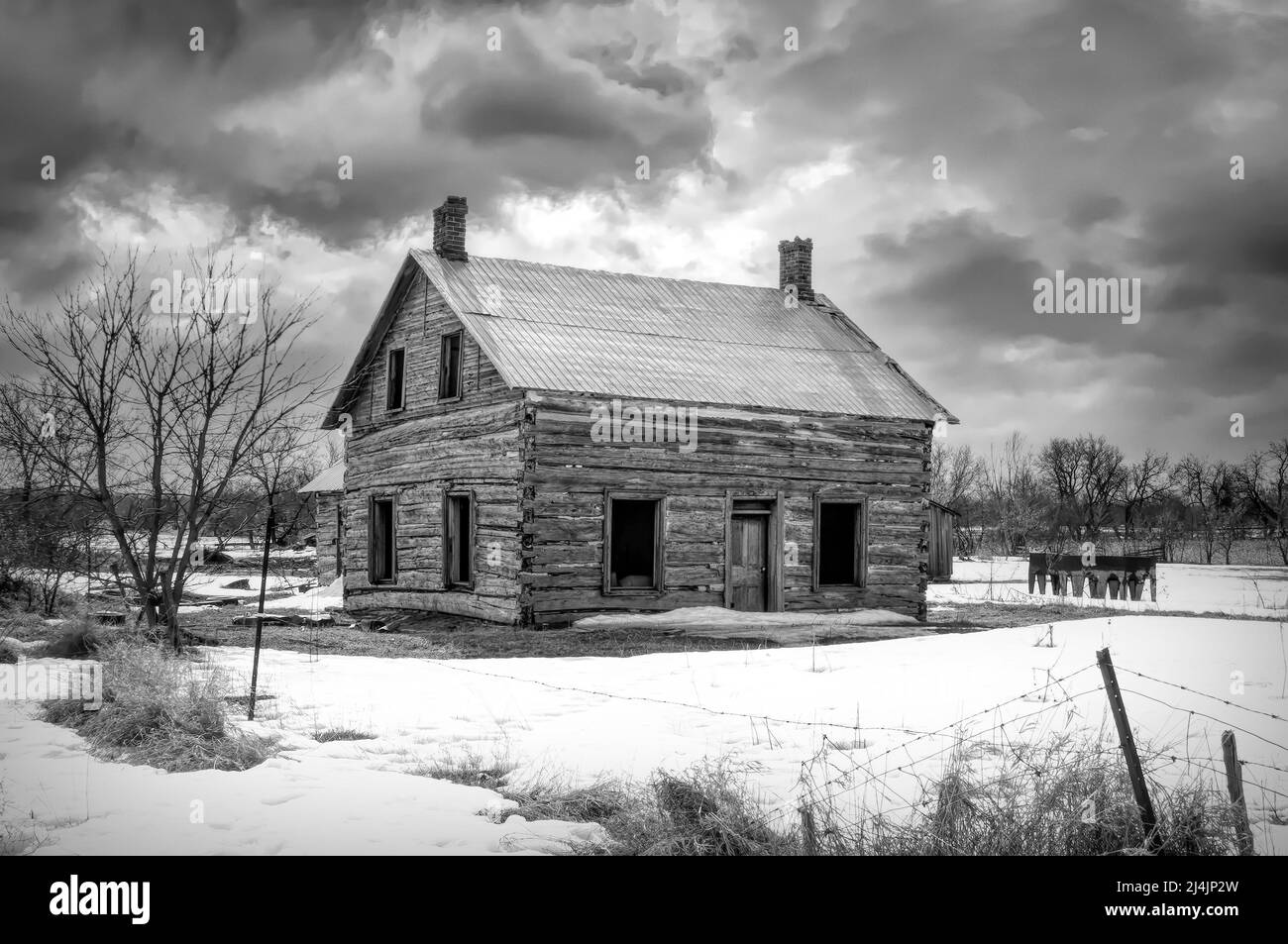 Un vecchio nero e bianco abbandonato spooky cercando fattoria in inverno su un cortile fattoria nel Canada rurale Foto Stock