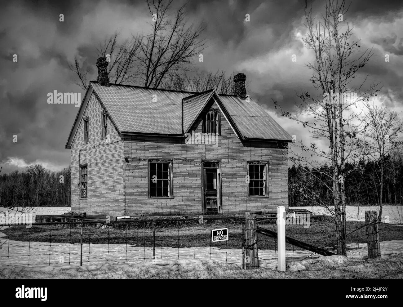 Un vecchio nero e bianco abbandonato spooky cercando fattoria in inverno su un cortile fattoria nel Canada rurale Foto Stock