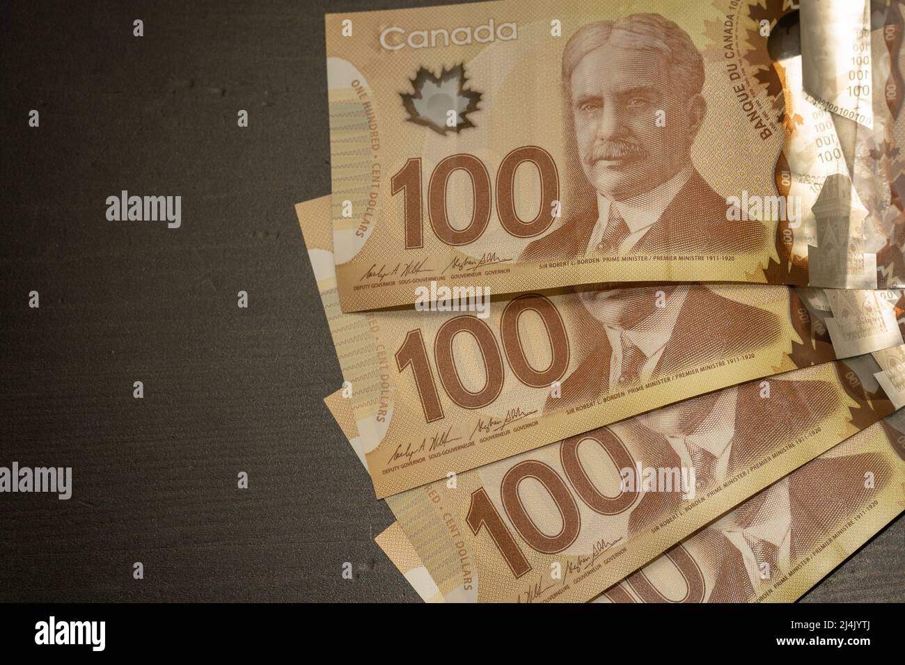 Primo piano di cento (100) dollari canadesi bruni con backround nero e spazio copia. Foto Stock