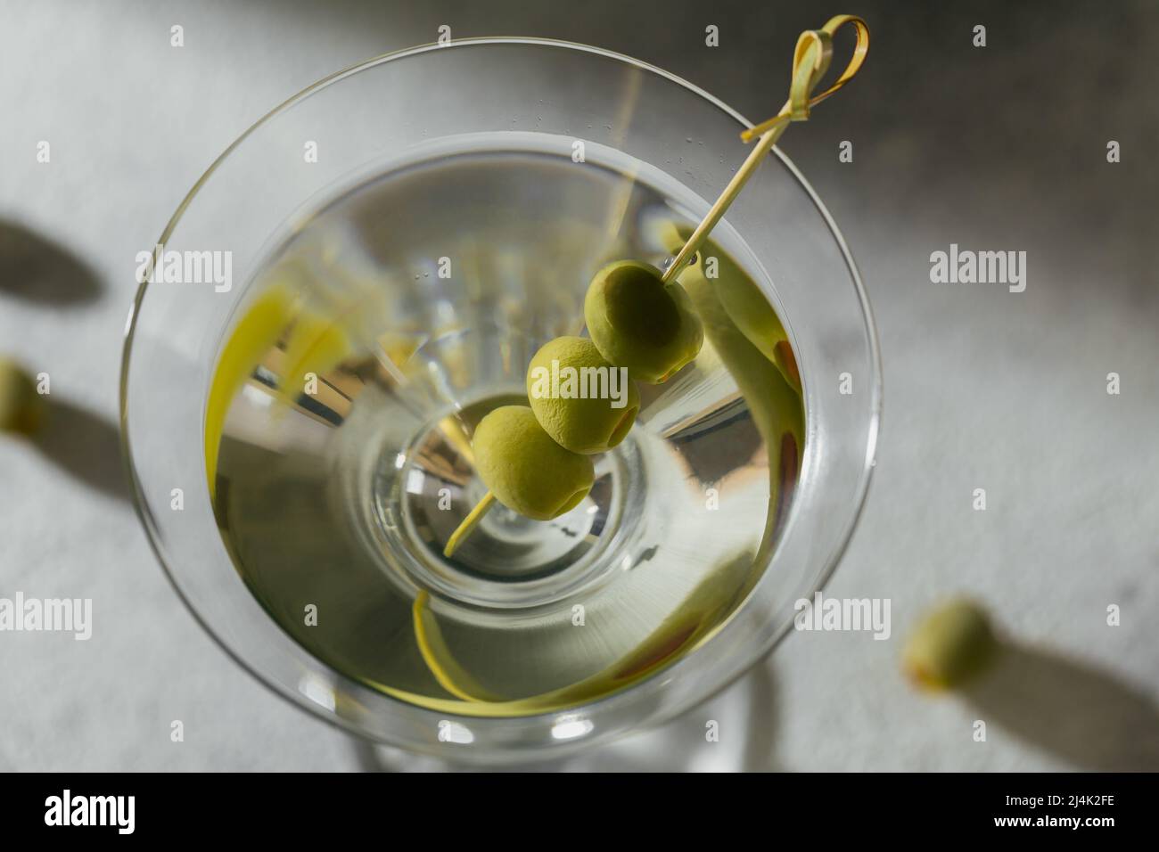 Bicchiere di classico cocktail martini secco con olive su sfondo di pietra grigia Foto Stock