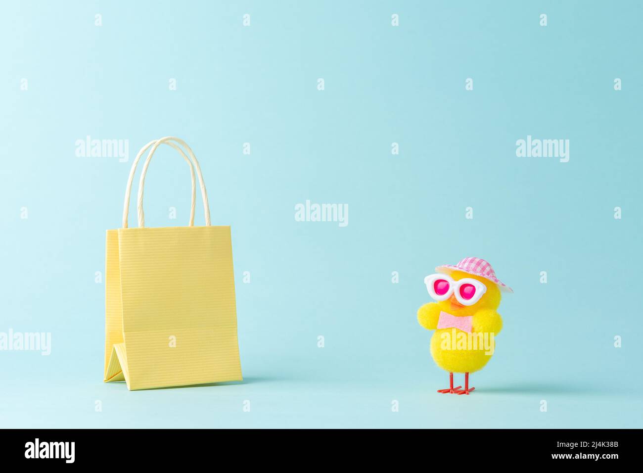 Concetto di shopping minimale creativo fatto con il pollo carino e la borsa della spesa. Disposizione dello shopping primaverile. Foto Stock