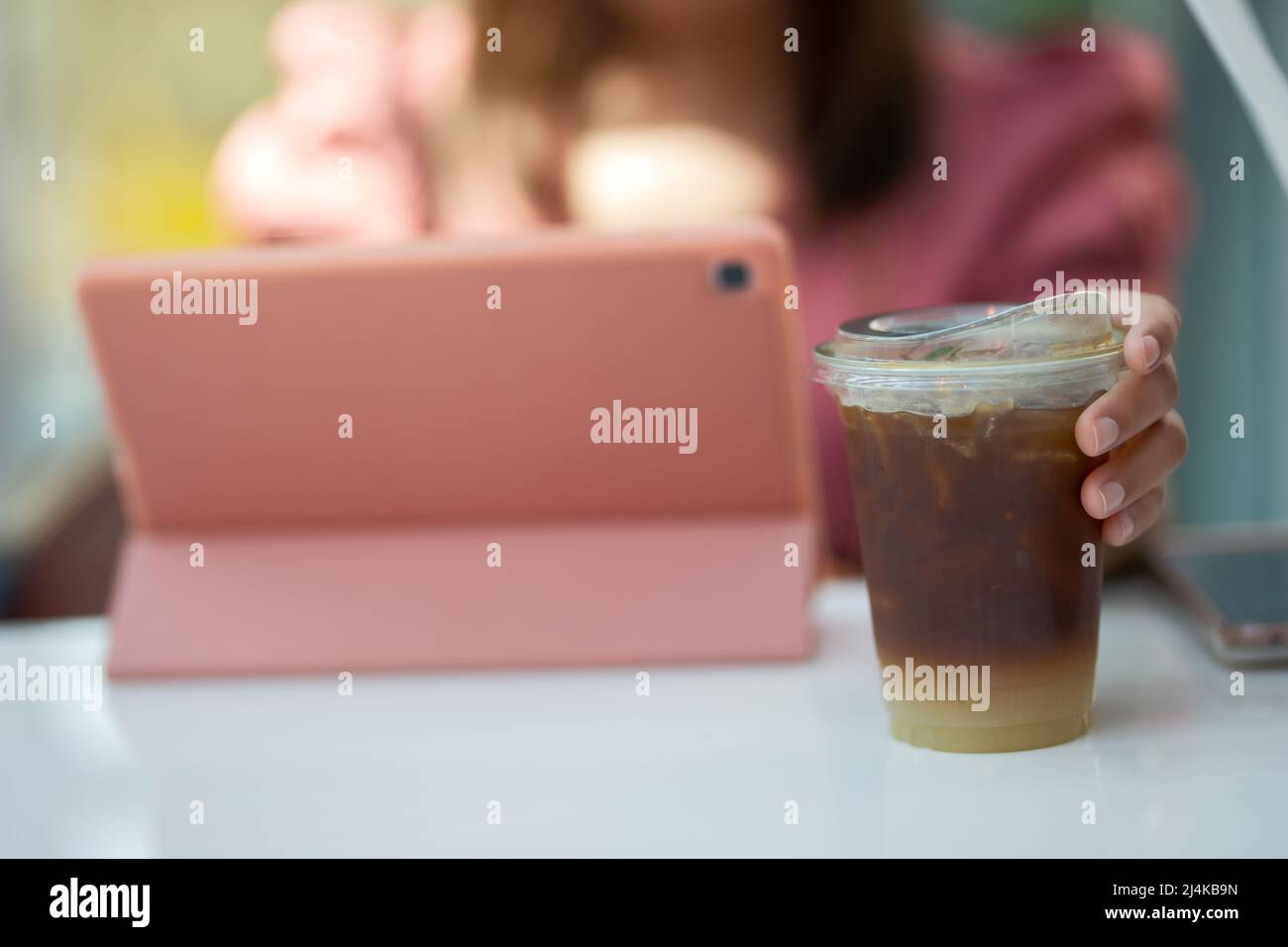 Mano donna che tiene il bicchiere di caffè ghiacciato Foto Stock