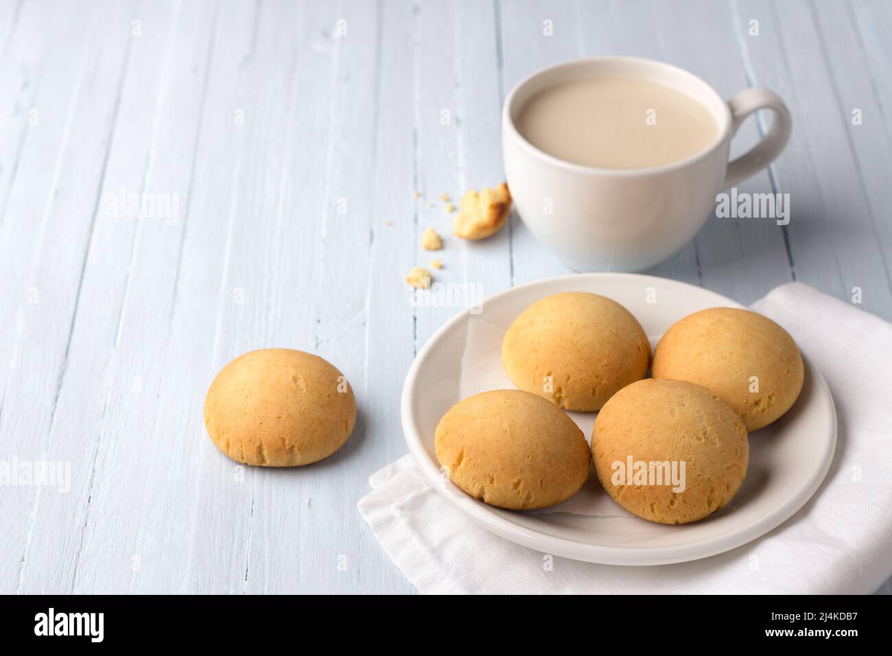 Biscotti fatti in casa senza glutine al riso casereccio e una tazza di tè con latte su sfondo chiaro Foto Stock