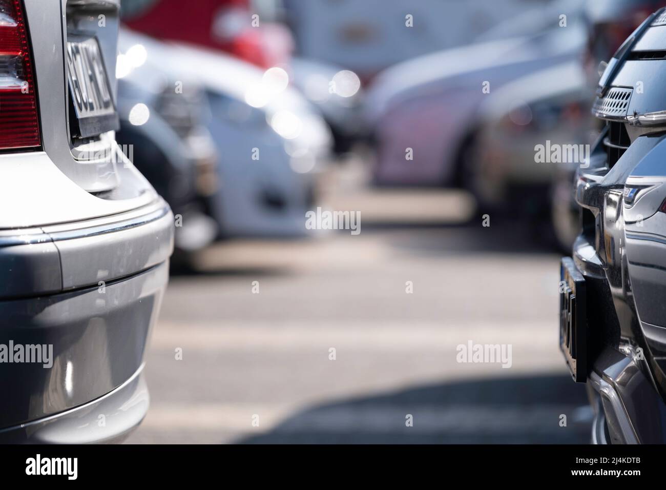 Due auto in un parcheggio. A sinistra una macchina con un tedesco, a destra con una targa olandese. Auto sfocate sullo sfondo, luogo per il testo Foto Stock