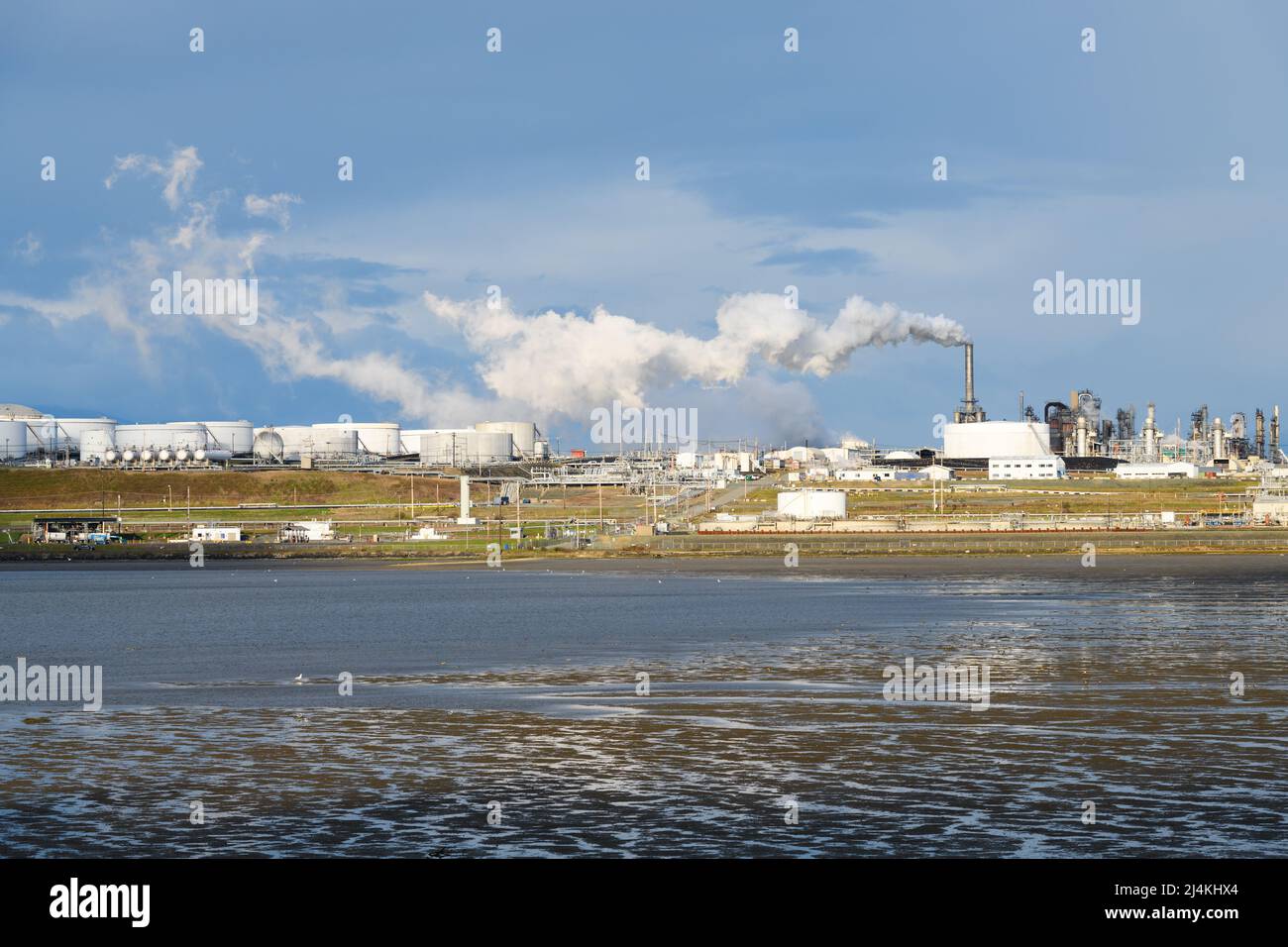Anacortes, WA, USA - 12 aprile 2022; complesso industriale a vapore che sale attraverso la riserva acquatica di Fidalgo Bay nel Pacifico nord-occidentale Foto Stock