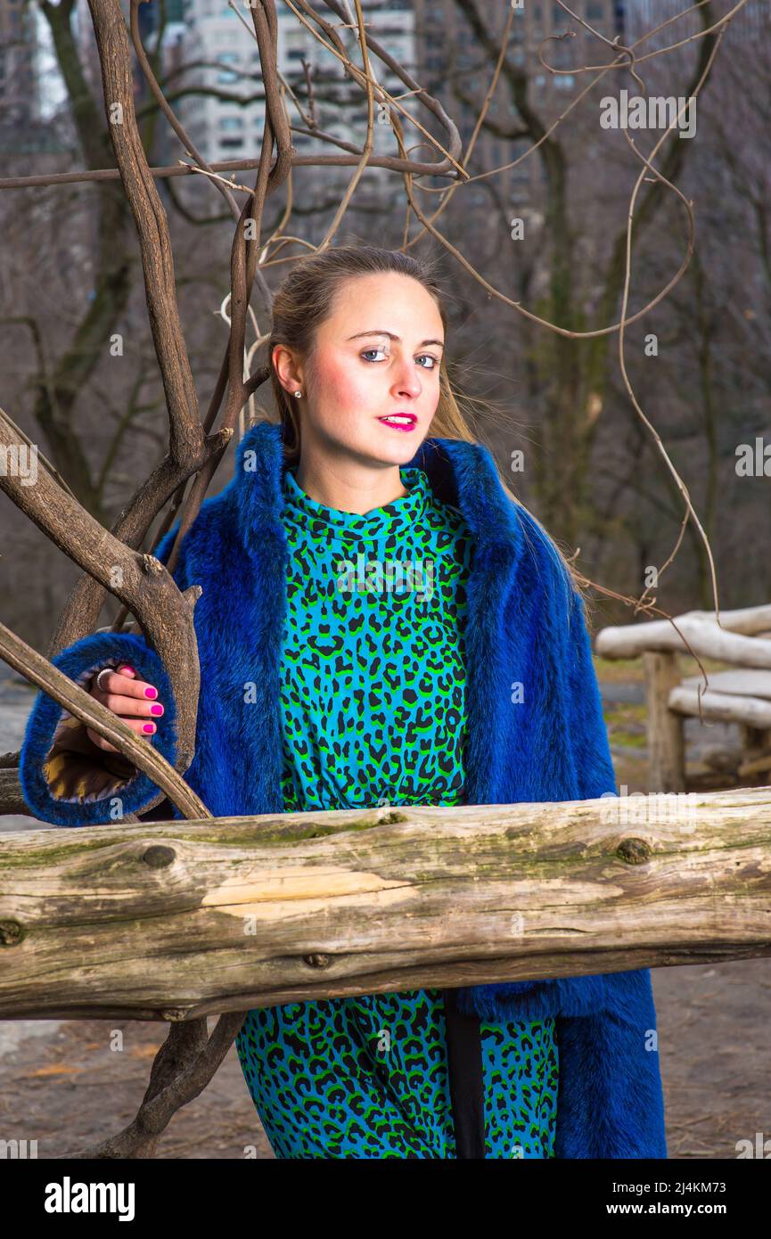 Vestendo in pelliccia sintetica blu cappotto e abito a motivi geometrici,  una donna graziosa vi sta guardando in un inverno freddo Foto stock - Alamy