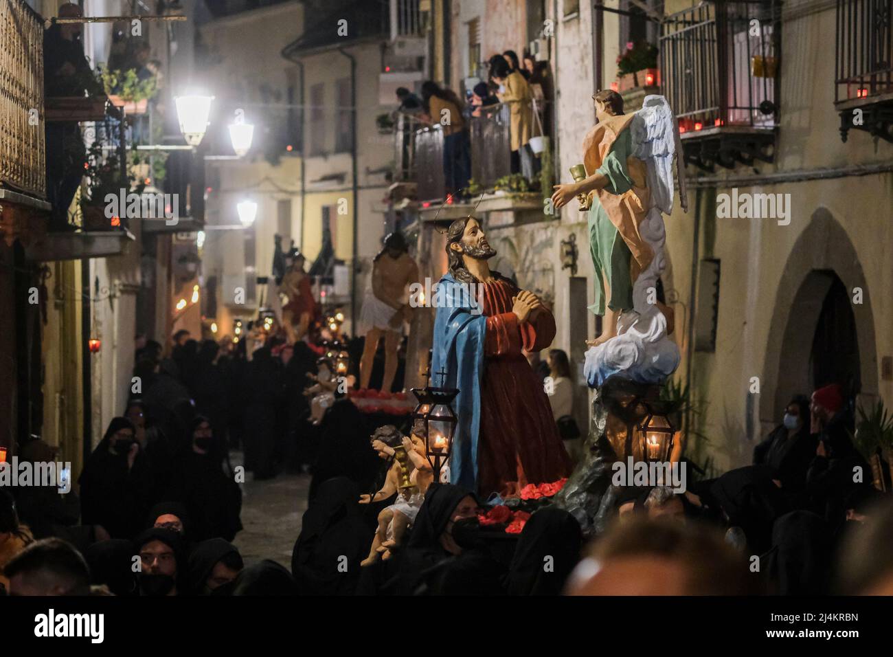 Dopo un periodo di due anni, le processioni del Venerdì Santo tornano a Sessa Aurunca il 17 aprile 2022. Gli uomini che indossano cappe nere e che sono affiliati all'Arciconfraternita della Santa Croce sfilano per le strade della città ed eseguono una 'dance' lenta e ondeggiante. È il passo rituale chiamato 'cunnulella', eseguito portando religiosamente le statue dei Misteri sulle loro spalle. Mentre passano, in vari punti si illuminano i carraciuni, enormi falò fatti da fasci raccolti e allestiti nei vari quartieri attraverso i quali passa la processione, simbolo di devozione a Cristo. Foto Stock
