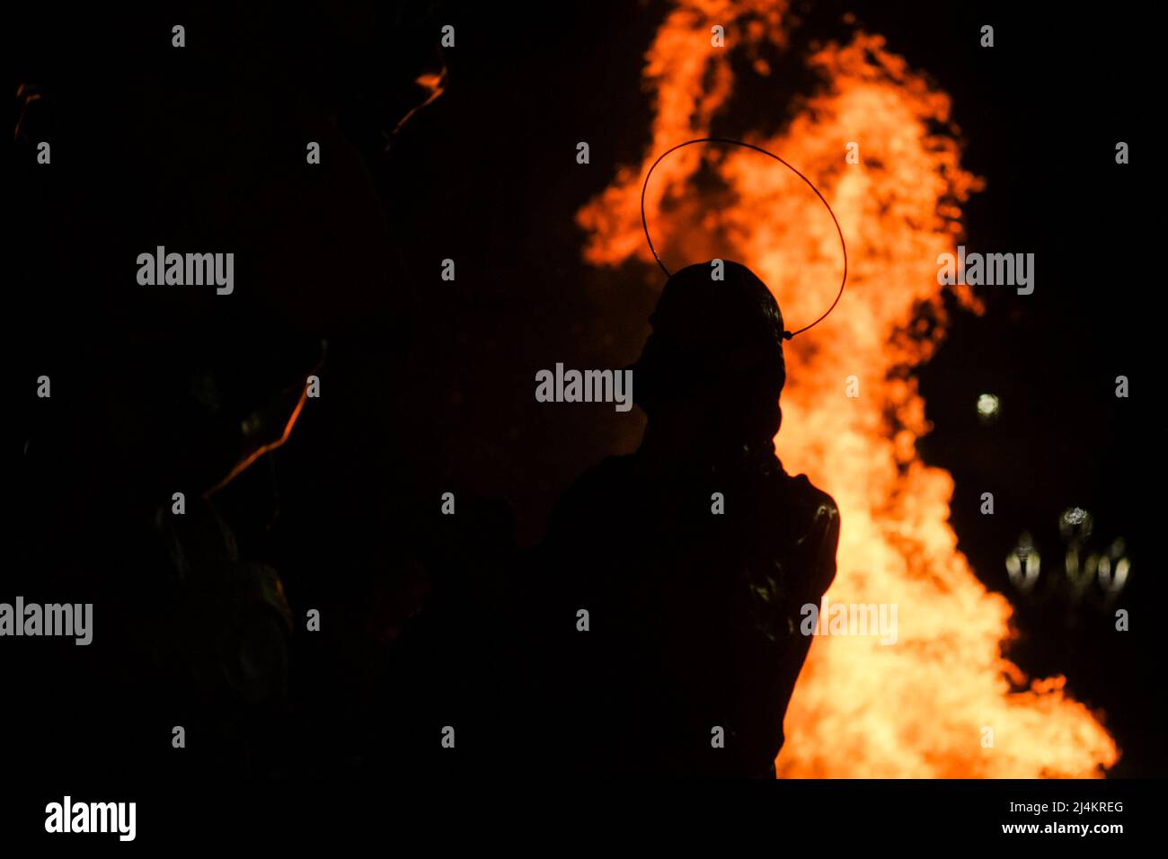 Dopo un periodo di due anni, le processioni del Venerdì Santo tornano a Sessa Aurunca il 17 aprile 2022. Gli uomini che indossano cappe nere e che sono affiliati all'Arciconfraternita della Santa Croce sfilano per le strade della città ed eseguono una 'dance' lenta e ondeggiante. È il passo rituale chiamato 'cunnulella', eseguito portando religiosamente le statue dei Misteri sulle loro spalle. Mentre passano, in vari punti si illuminano i carraciuni, enormi falò fatti da fasci raccolti e allestiti nei vari quartieri attraverso i quali passa la processione, simbolo di devozione a Cristo. Foto Stock