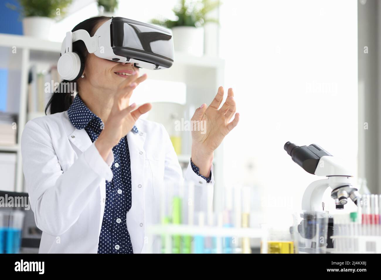 Medico in occhiali virtuali in laboratorio conduce esperimento Foto Stock