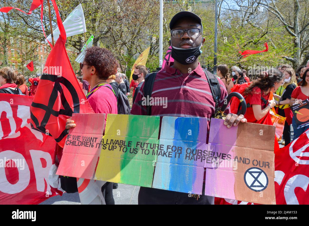 Un giovane attivista del clima è visto tenere segno pro la giustizia del clima al parco di Washington Square, New York City il 16 aprile 2022. Foto Stock