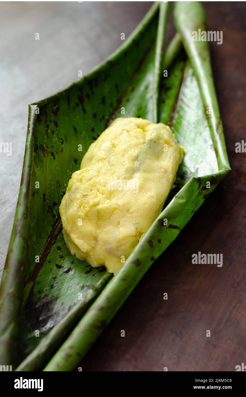 Piatto tradizionale TradioColombiano e messicano preparato con pasta di mais e ripieno di pollo, maiale, costolette di maiale, verdure, avvolto in foglie di banana, vapore. Foto Stock