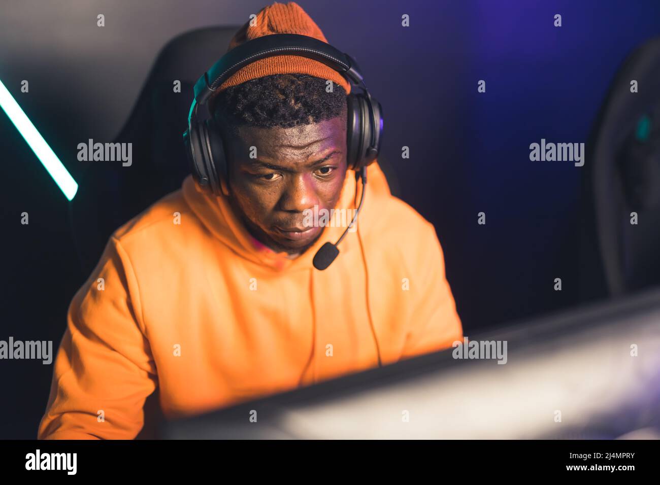 Professionista Afro American uomo giocare e streaming online video gioco battaglia cyber sport medio closeup indoor. Foto di alta qualità Foto Stock
