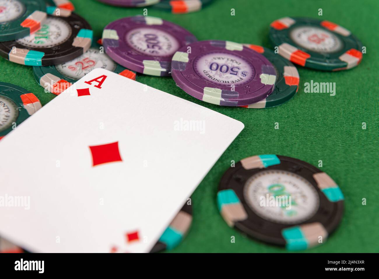 Un asso di diamanti si siede su un mucchio di fiches di poker. Foto Stock