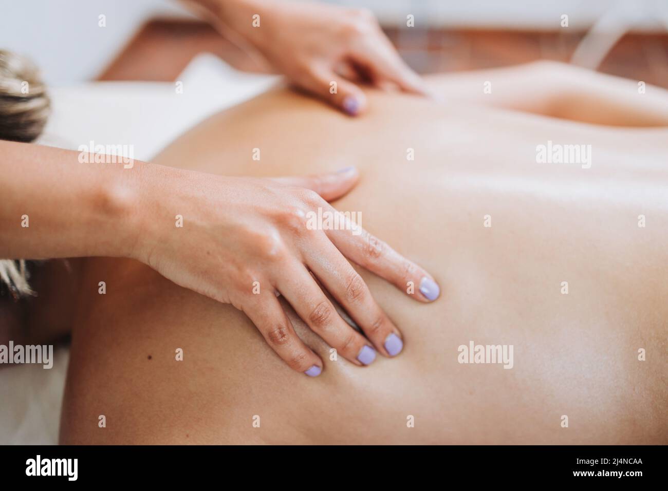 Terapista irriconoscibile che fa il massaggio della schiena e della scapola ad una paziente femminile con dolore alla schiena. Relax e stress Foto Stock