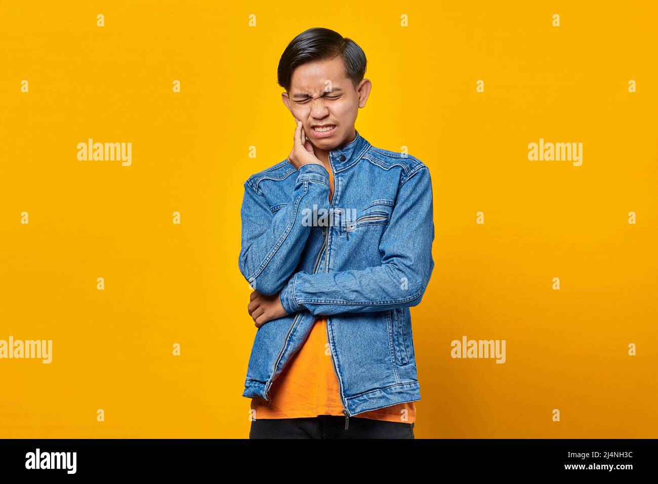 Ritratto dell'uomo asiatico che tocca la bocca con espressione dolorosa Foto Stock