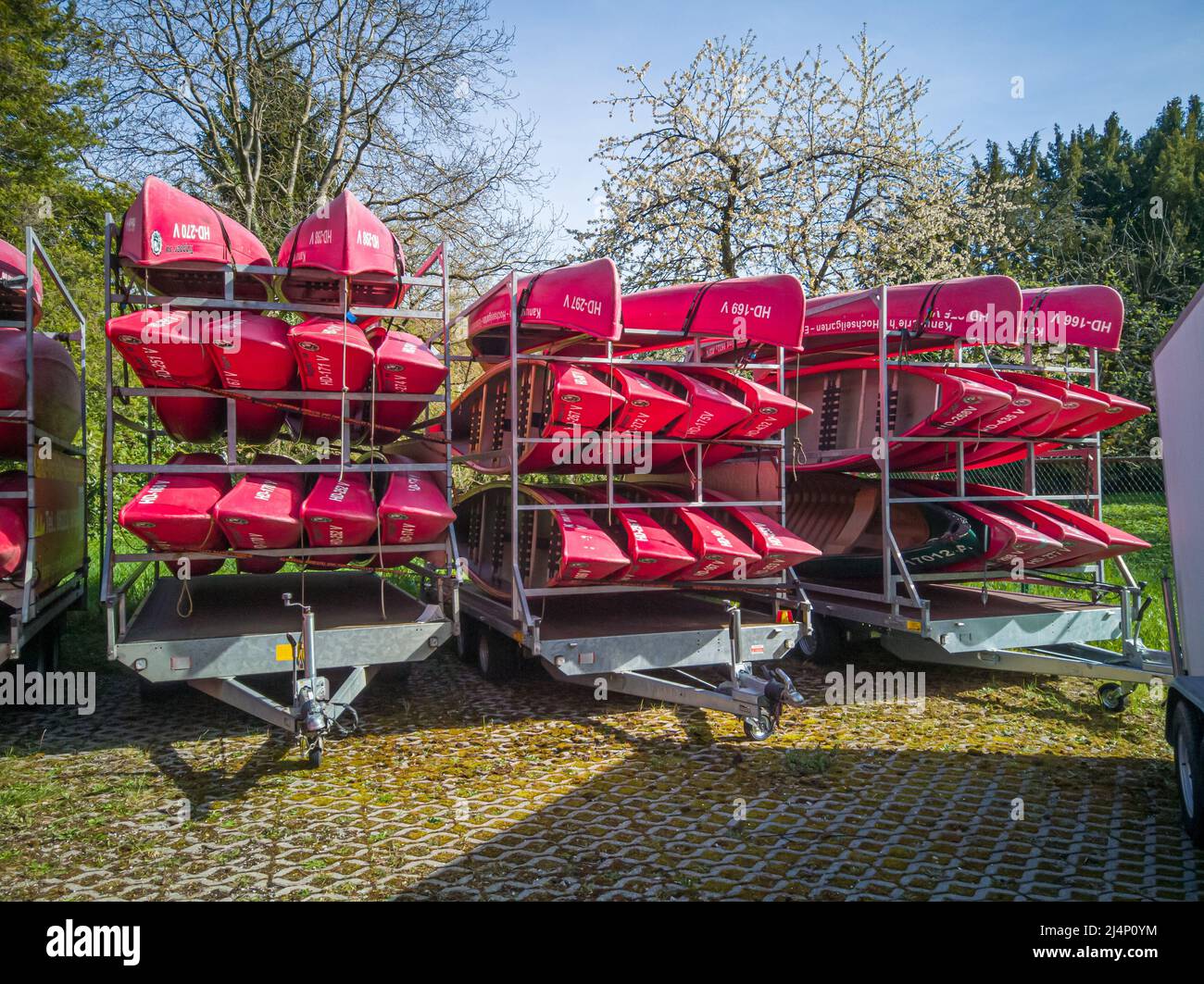 Neckargemuend, Germania: 11 aprile 2022: Canoe rosse su un rimorchio auto in primavera in attesa di essere utilizzato per tour turistici sul fiume in estate Foto Stock