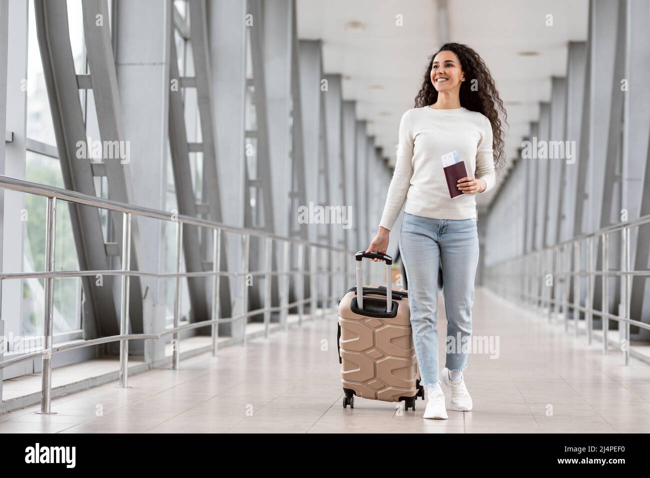 Felice giovane donna sorridente che cammina con i bagagli al Terminal dell'Aeroporto Foto Stock