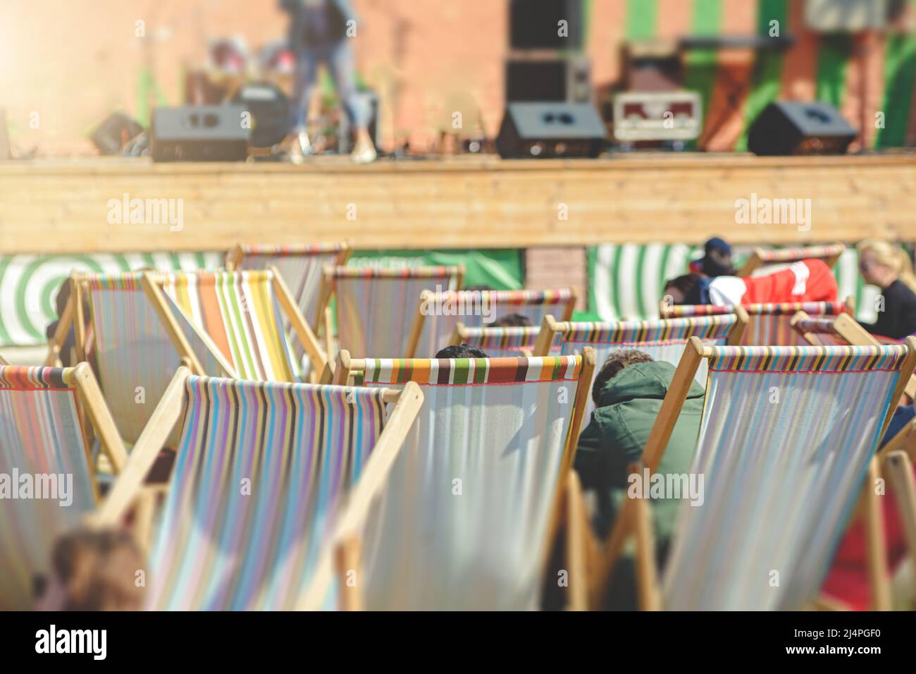 Le persone sedute in poltrone riposano su un concerto di strada Foto Stock