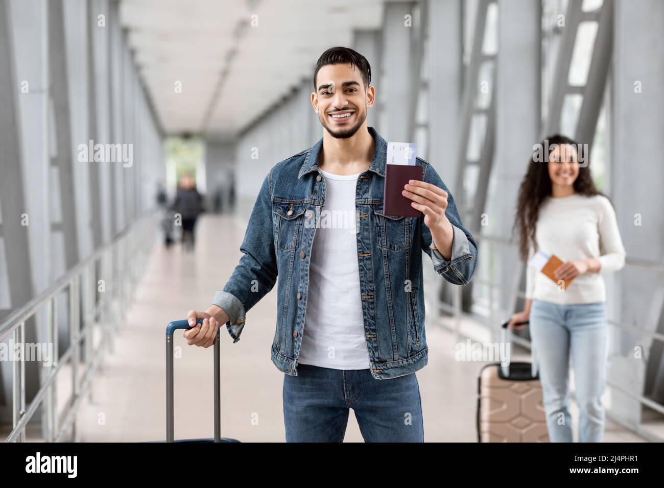 Servizio di prenotazione voli. Arab Man in posa con passaporto e biglietti all'aeroporto Foto Stock