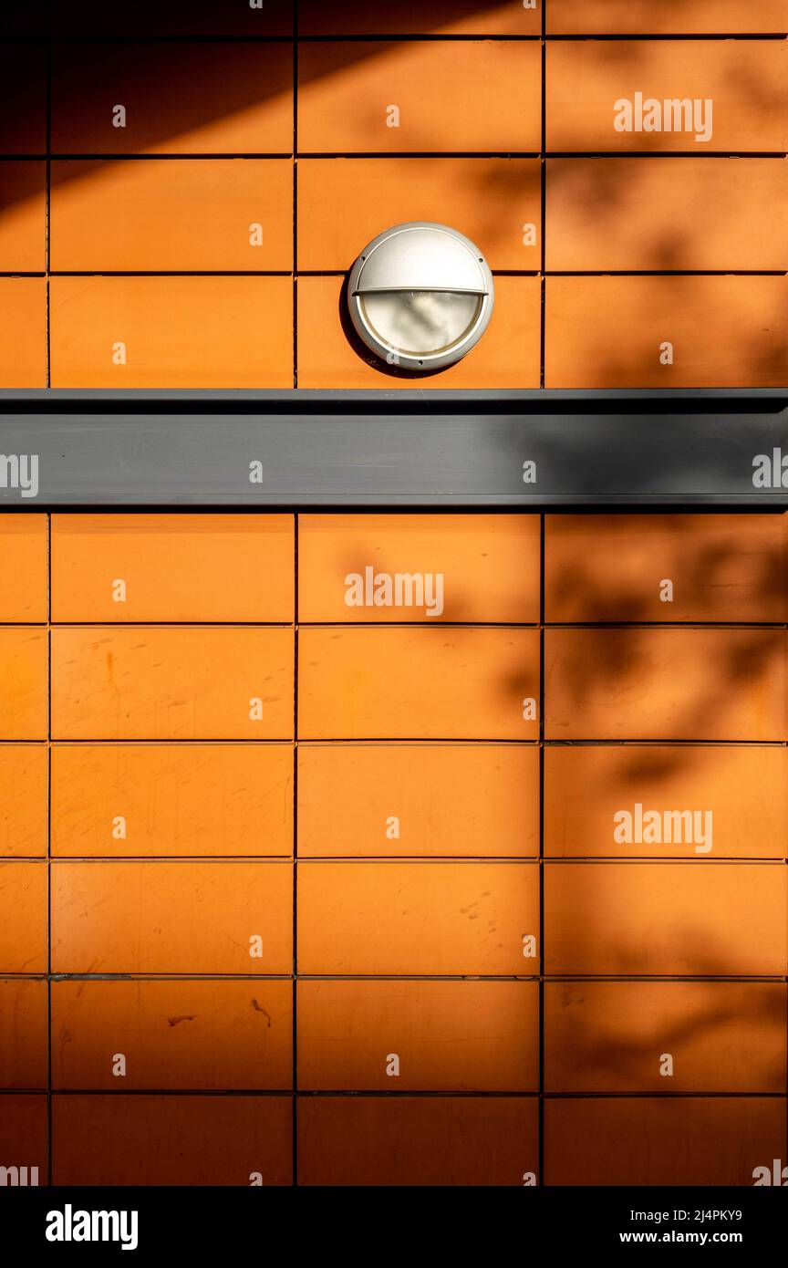 Epsom Surrey London UK, aprile 17 2022, piastrelle esterne in pietra arancione brillante e luci esterne su un moderno edificio residenziale Foto Stock