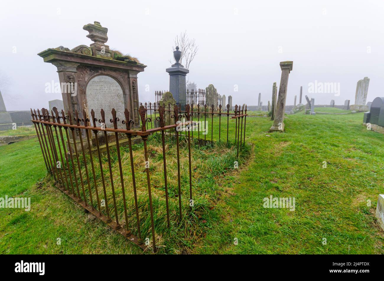 Mortsafe, protezione in ferro contro i cadaveri, in un cimitero confuso, County Antrim, Irlanda del Nord. Foto Stock