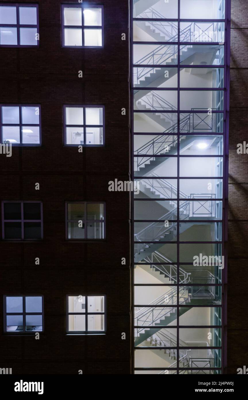 Scala illuminata di notte all'interno di un blocco di uffici. Foto Stock