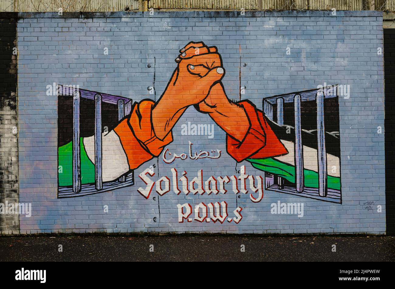 Il murale alla pace internazionale a parete, Belfast raffigurante la solidarietà tra Irish e prigionieri palestinesi Foto Stock