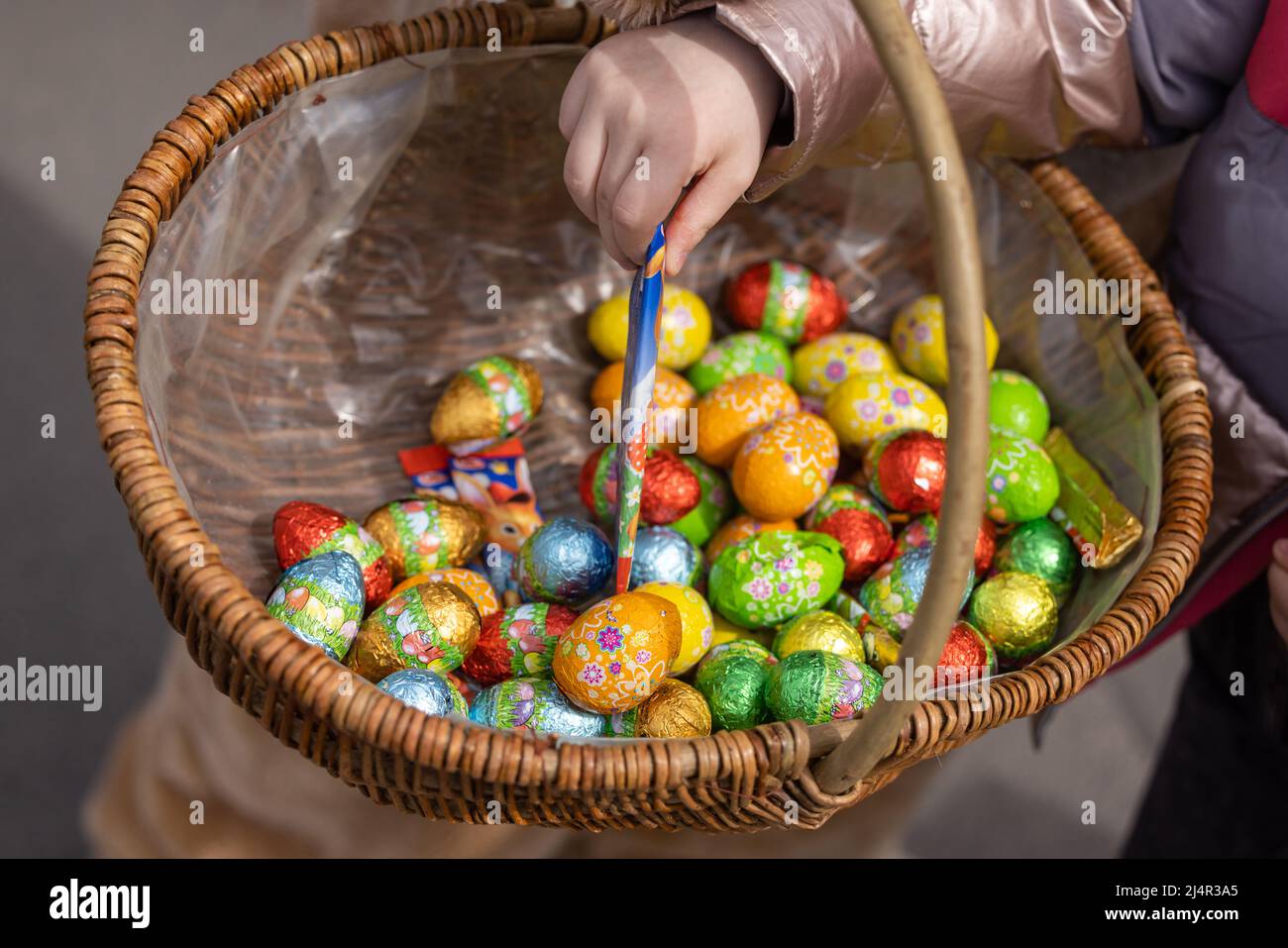 Erfurt, Germania. 17th Apr 2022. Un bambino prende il cioccolato da un cestino di uova di Pasqua distribuito da una persona in un costume da coniglio di Pasqua in Ega Park. La domenica di Pasqua tutti i bambini fino a 16 anni possono entrare gratuitamente nel parco. Credit: Michael Reichel/dpa/Alamy Live News Foto Stock
