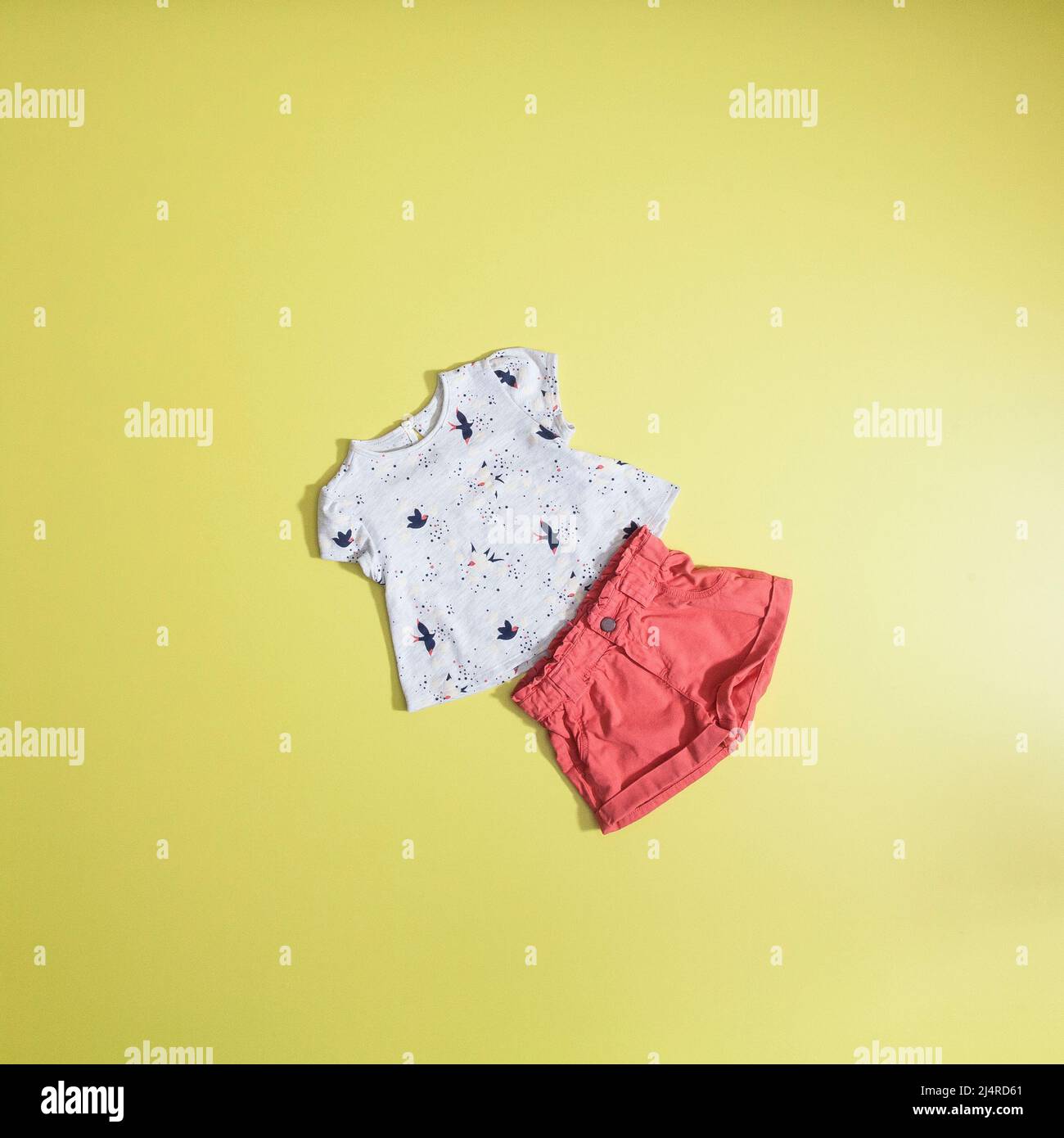 Moda bambino - Set camicia e shorts per ragazze; foto su sfondo giallo piatto. Foto Stock