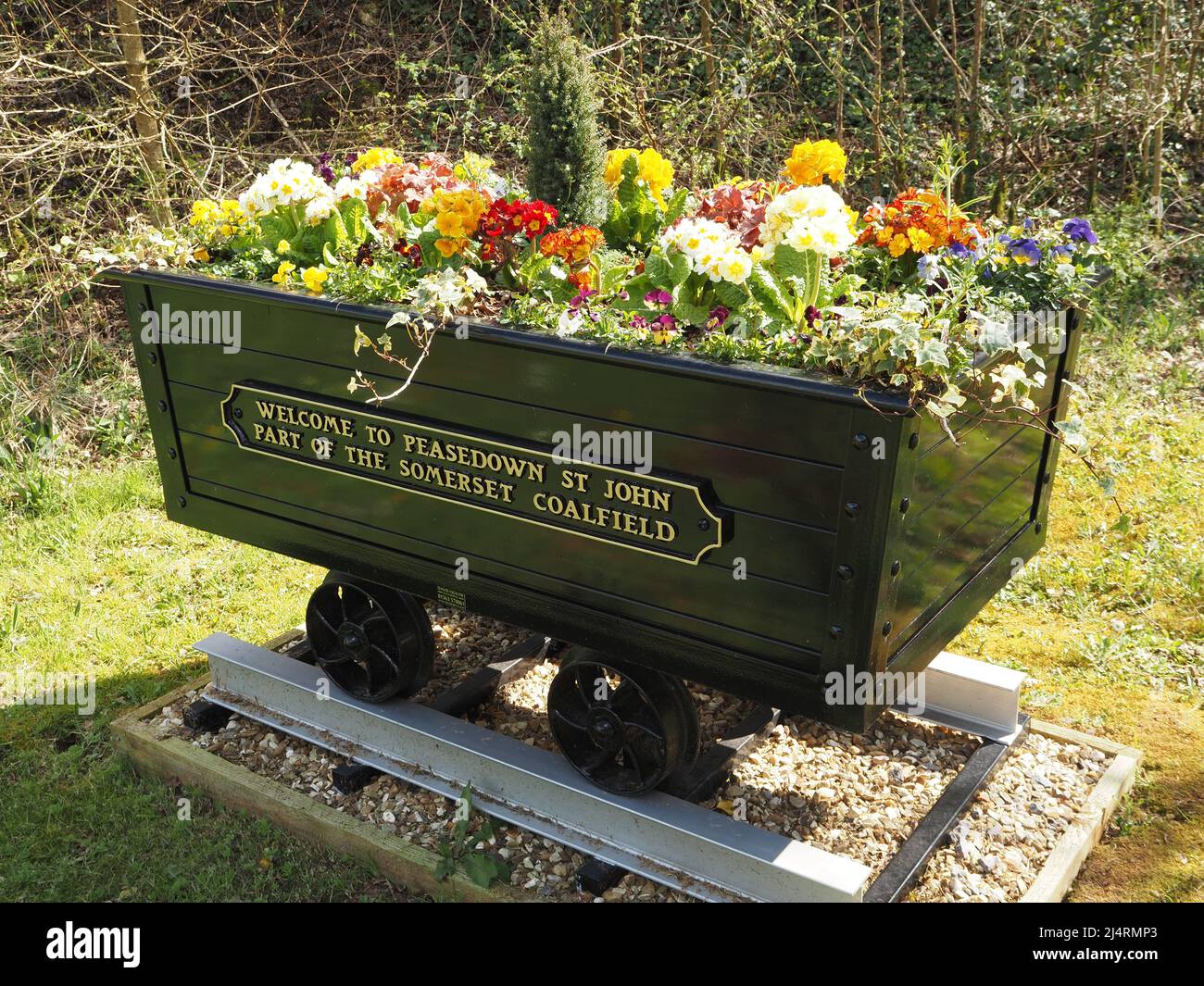 Mostra di fiori di primavera in una carrozza di tram a carbone a Peasedown St John, Somerset, Inghilterra, che celebra la storia del campo di carbone Somerset. Foto Stock