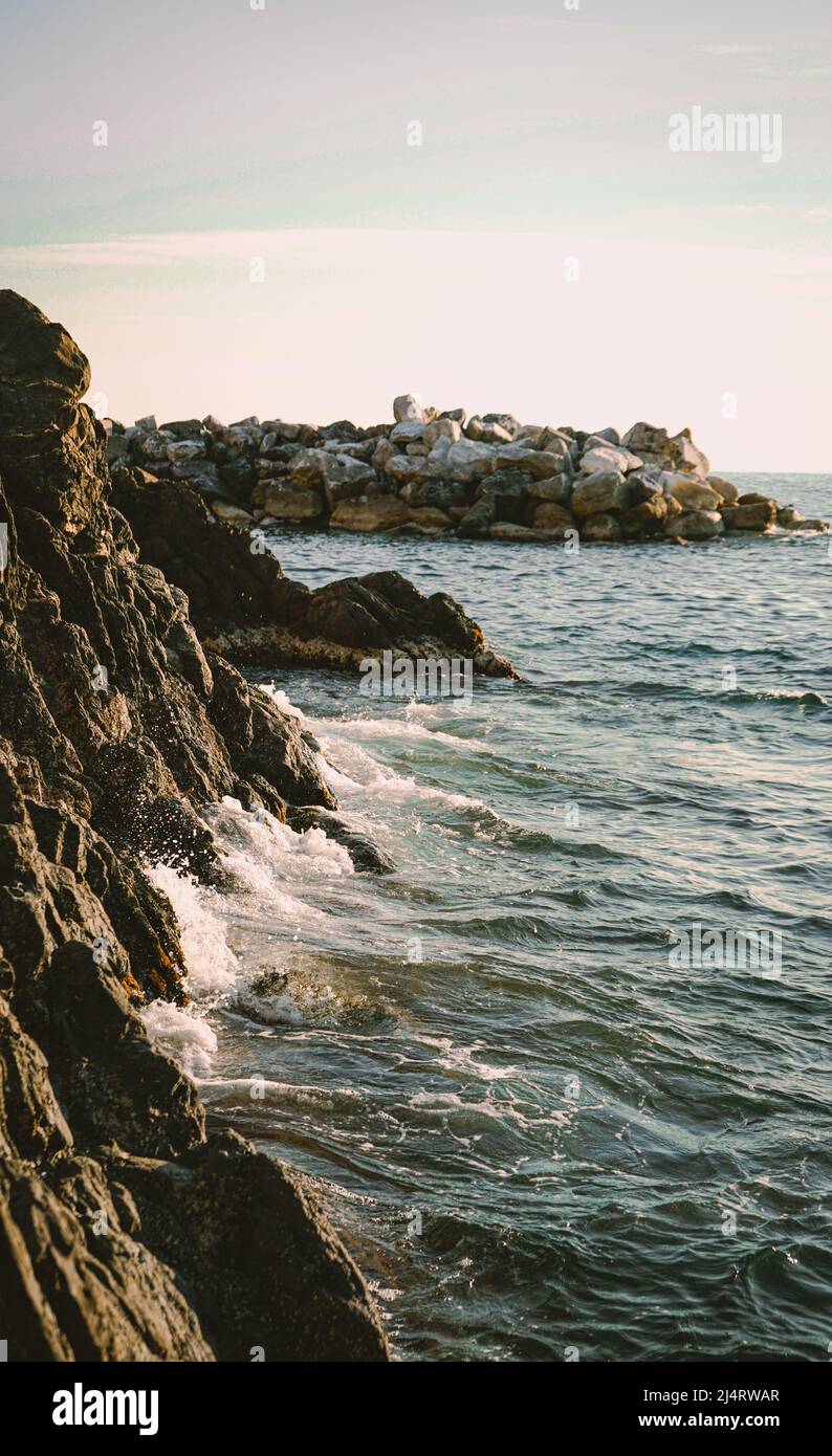 Acqua che colpisce le rocce del porto di Manarola, cinque Terre, Italia Foto Stock