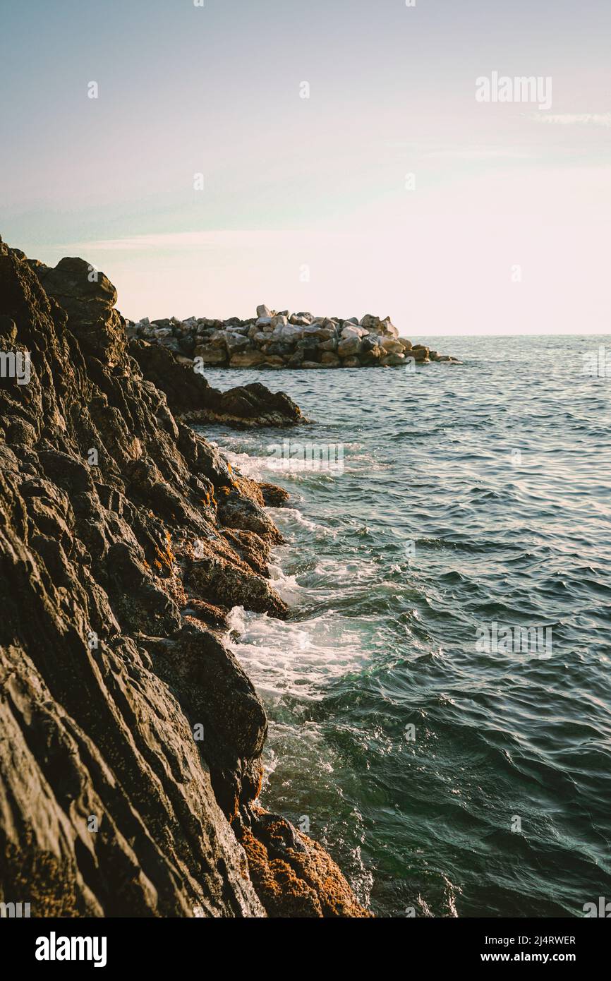 Acqua che colpisce le rocce del porto di Manarola, cinque Terre, Italia Foto Stock