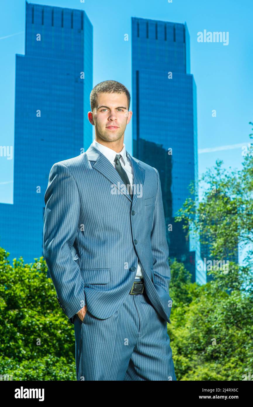 Ritratto di giovane uomo d'affari. Vestirsi formalmente in un abito blu, cravatta  nera, un ragazzo giovane professionista è in piedi di fronte al quartiere  degli affari, s Foto stock - Alamy