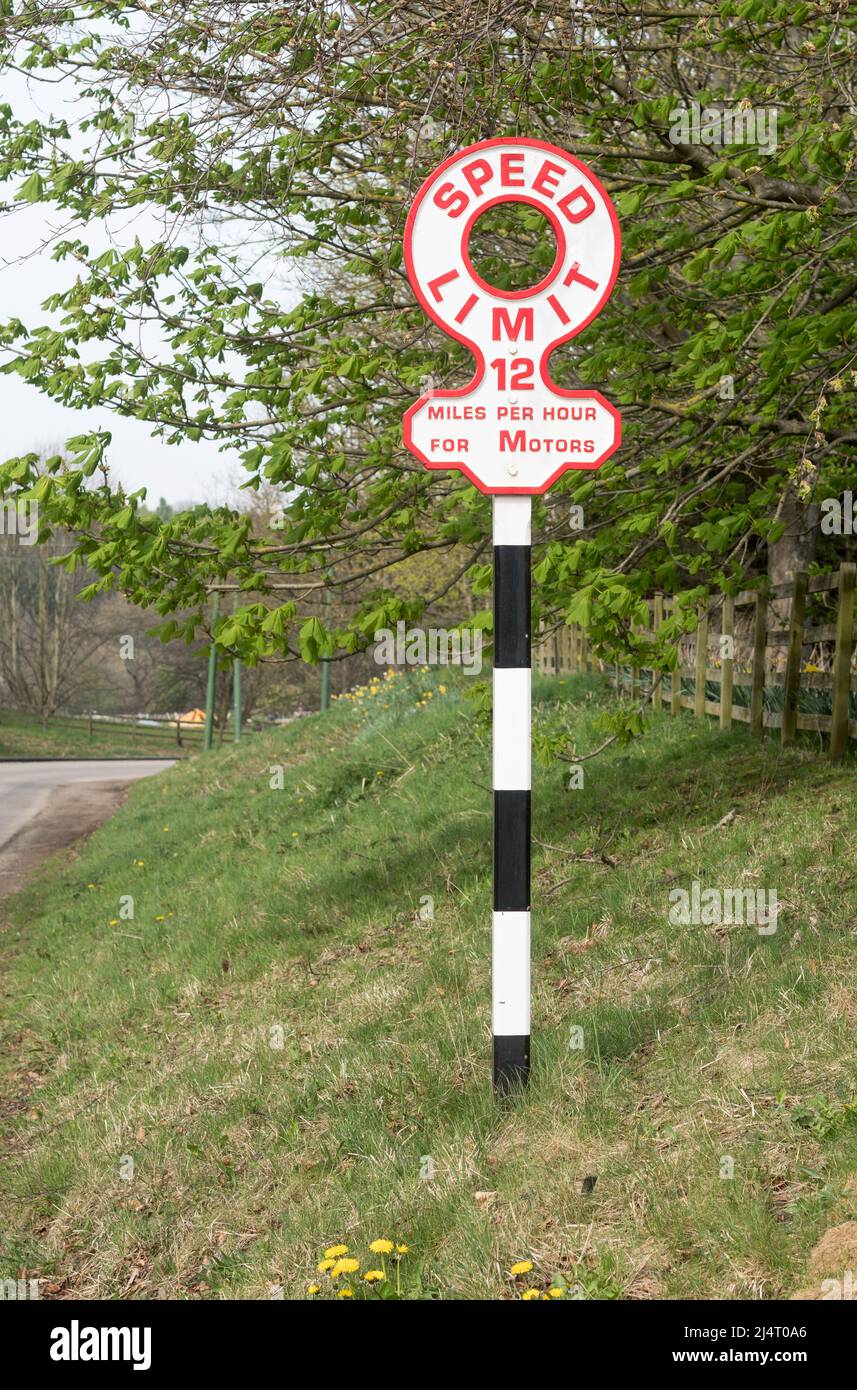 Un vecchio segnale del limite di velocità della strada che limita i motori a 12 mph, al museo di Beamish, Inghilterra nord-orientale, Regno Unito Foto Stock