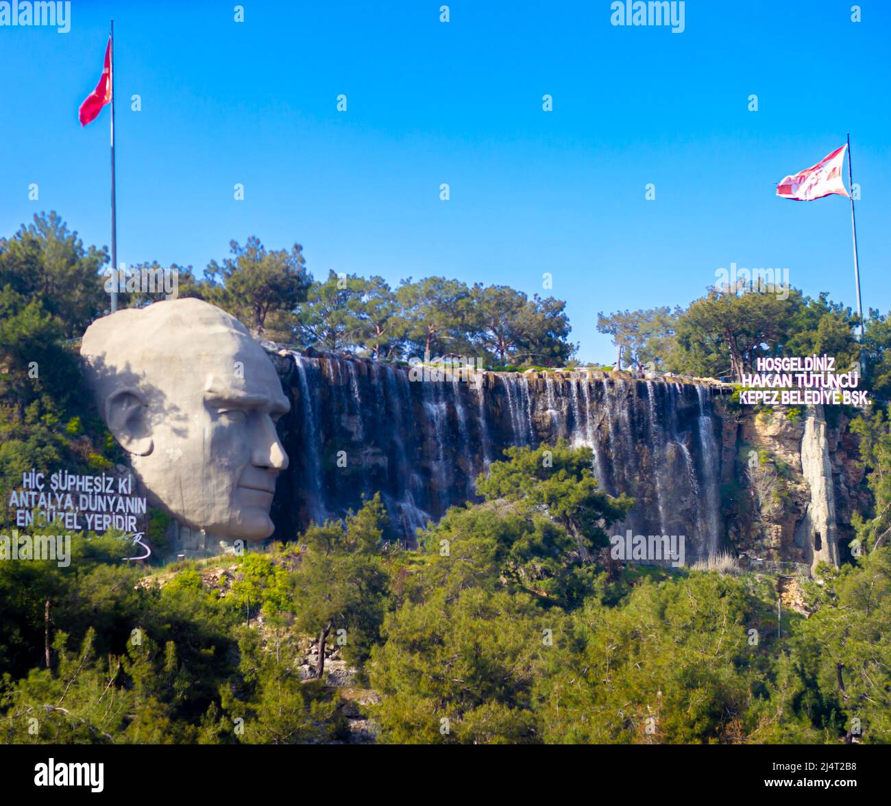 Kepez ingresso Atatürk statua e la sua parola per Antalya, cascata, bandiere. Foto Stock